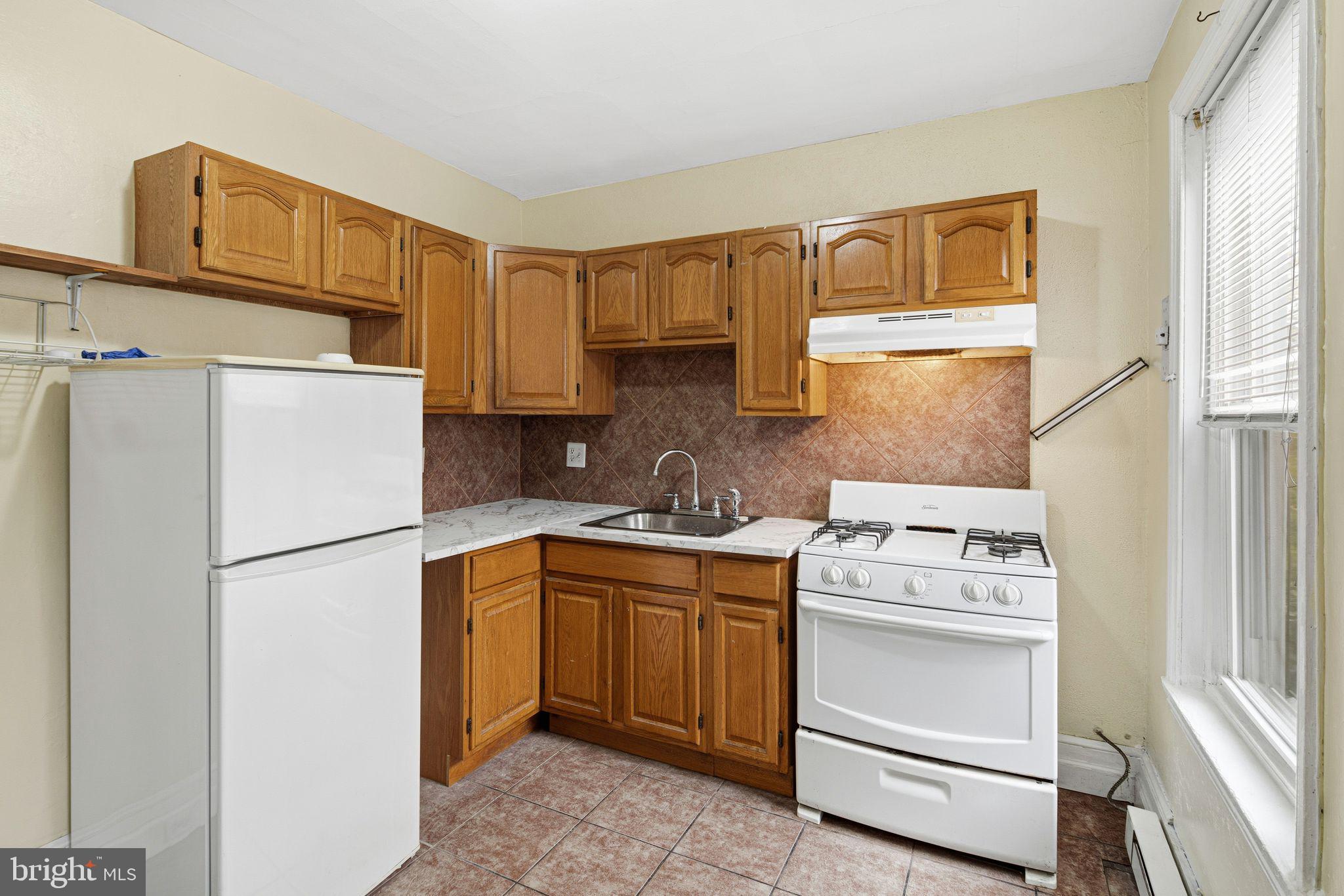 2914 Poplar Street Philadelphia, PA 19130 - Photo 21 of 32 a kitchen with a refrigerator sink stove and cabinets