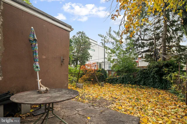 a backyard of a house with table and chairs