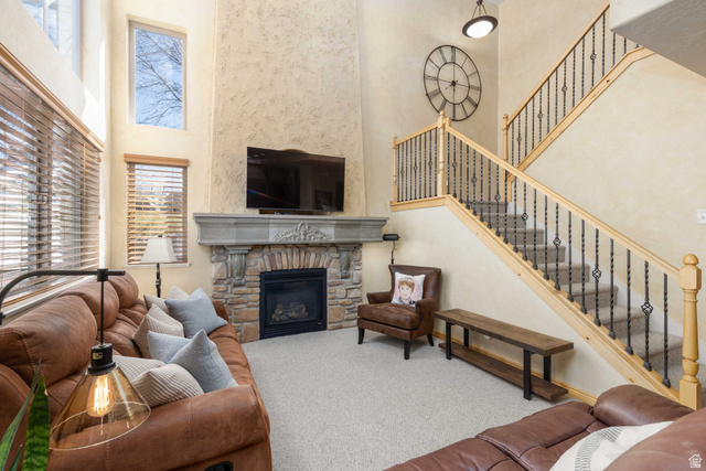5168 Fairview Loop, Unit C604 Eden, UT 84310 - Photo 13 of 53 Living area featuring a high ceiling, carpet flooring, and a fireplace