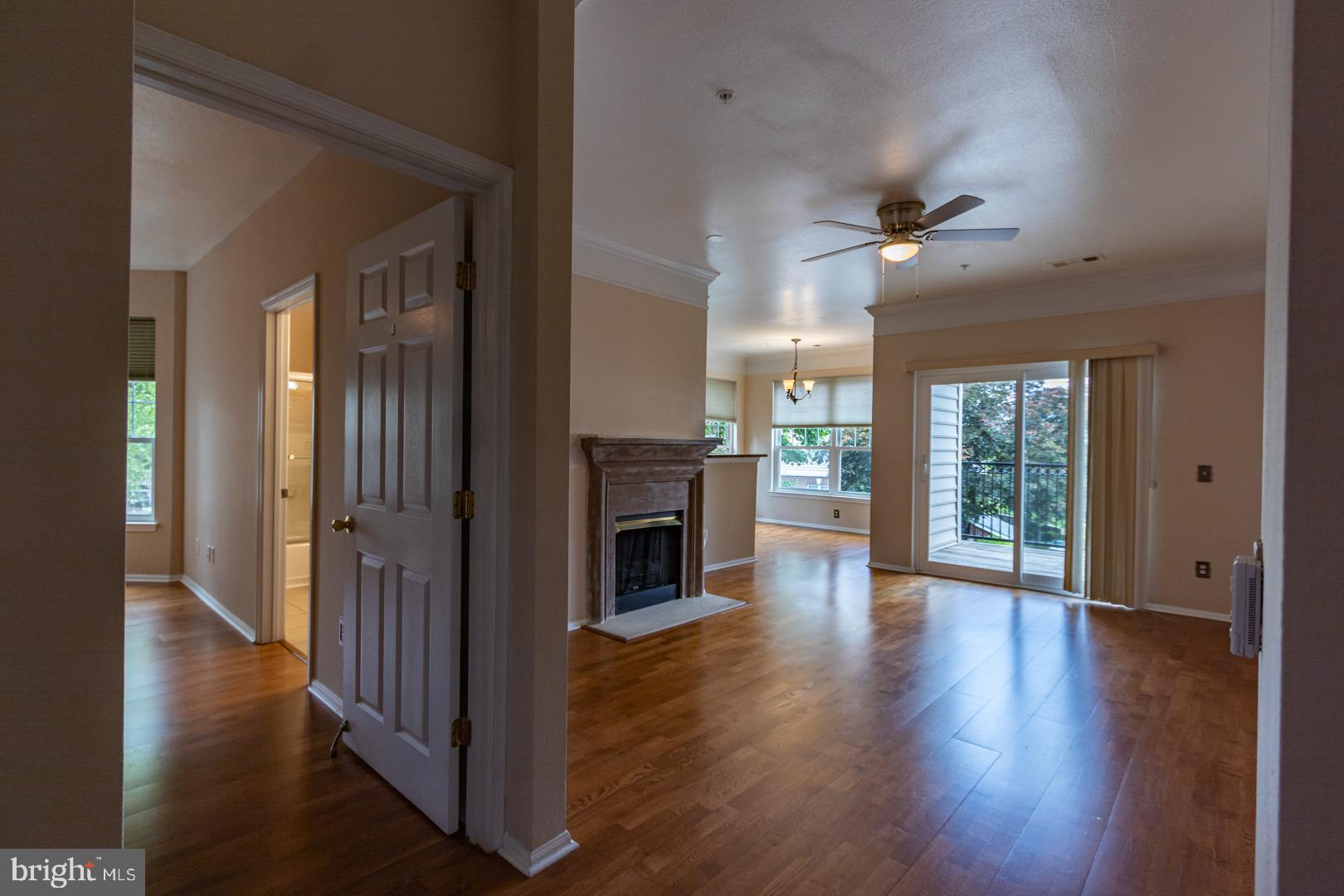 1600 Spring Gate Dr., Unit 2207 McLean, VA 22102 - Photo 3 of 32 an empty room with wooden floor fireplace and windows
