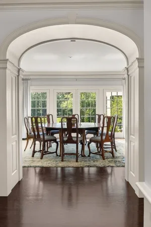 a dining room with furniture and a floor to ceiling window