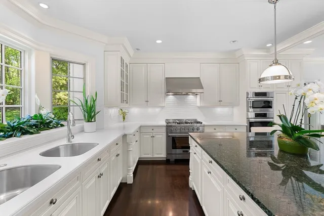 a kitchen with stainless steel appliances granite countertop sink stove and refrigerator