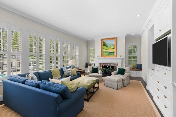 a living room with furniture flat screen tv and a large window