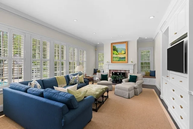 a living room with furniture flat screen tv and a large window