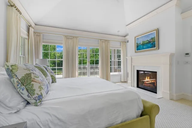 a large bed sitting in a bedroom next to a fireplace with a window
