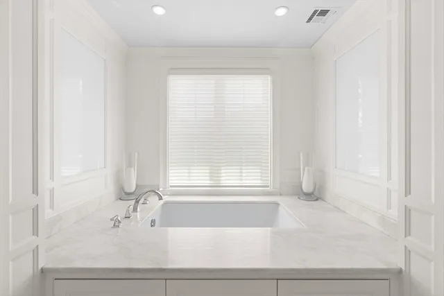 a bathroom with a bathtub and next to a window