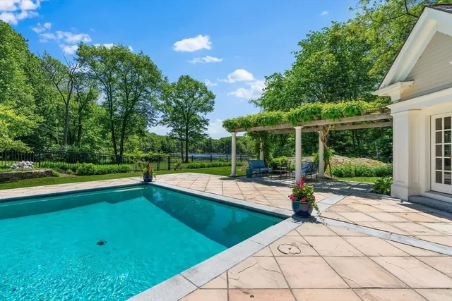 a view of backyard with swimming pool and outdoor seating