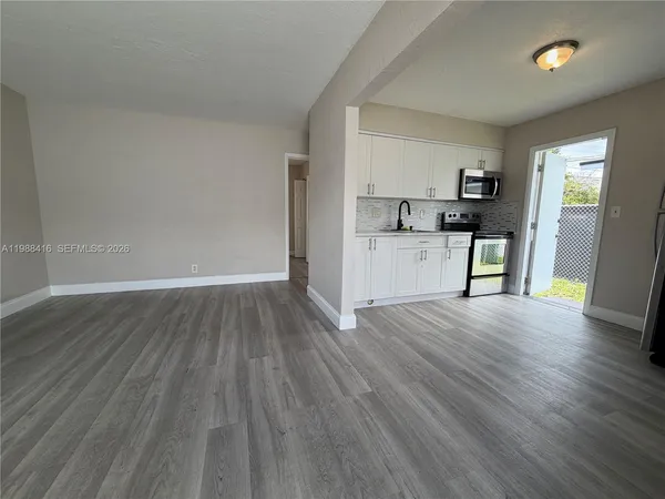 a view of a kitchen with a sink and dishwasher a refrigerator with wooden floor