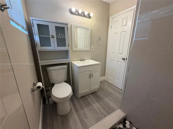a bathroom with a toilet sink and mirror