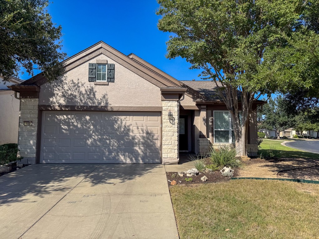 100 Sunbird Court Georgetown, TX 78633 - Photo 2 of 40 View of front of house with driveway, stucco siding, a front yard, stone siding, and an attached garage