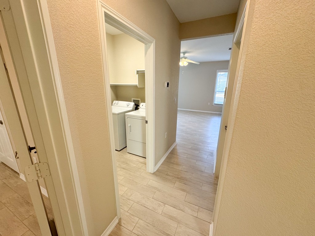 100 Sunbird Court Georgetown, TX 78633 - Photo 33 of 40 Corridor with a textured wall, light wood finished floors, and washer and clothes dryer