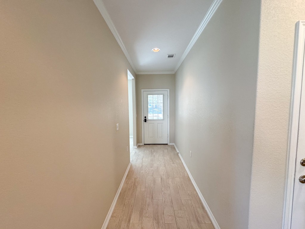 100 Sunbird Court Georgetown, TX 78633 - Photo 6 of 40 Hallway with crown molding and light wood-style flooring