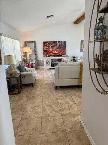 a living room with furniture a flat screen tv and a window
