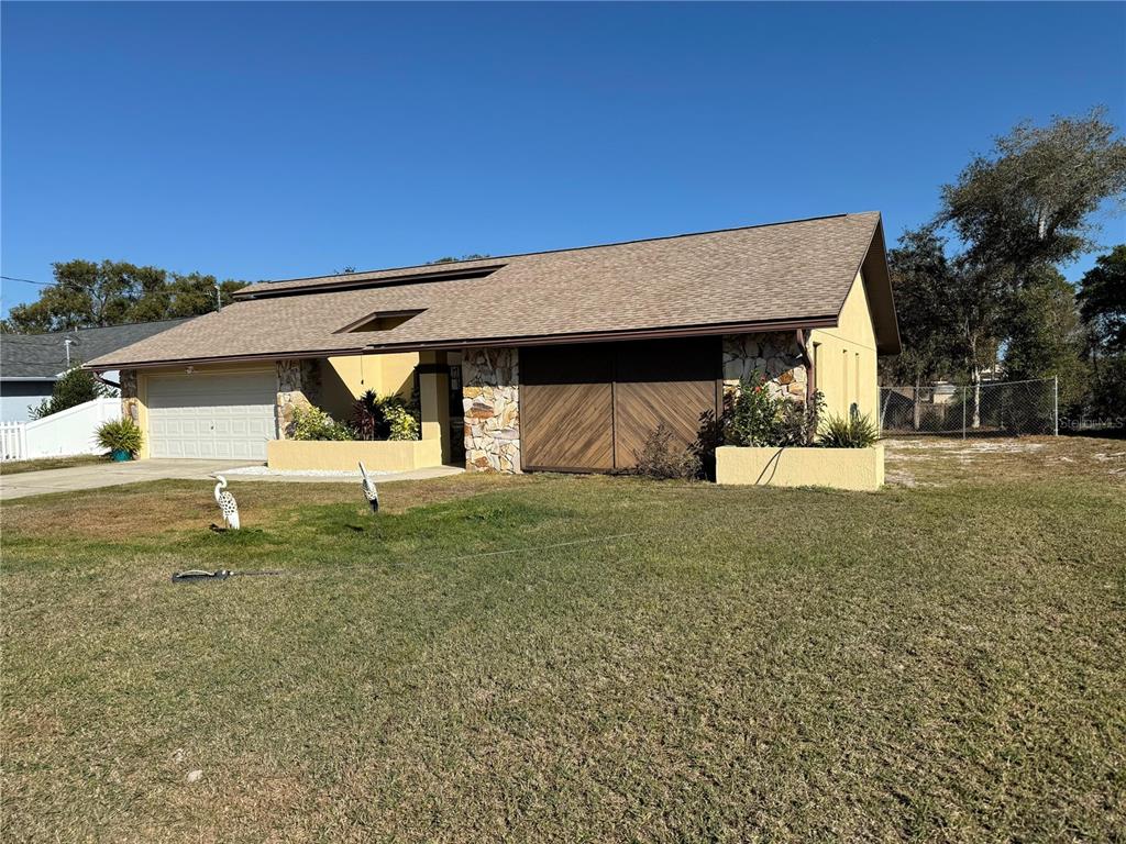 5389 Frost Road Spring Hill, FL 34606 - Photo 3 of 60 a front view of a house with a yard