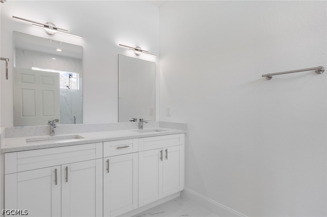 3408 14th Street Southwest Lehigh Acres, FL 33976 - Photo 16 of 24 a bathroom with a double vanity sink and mirror