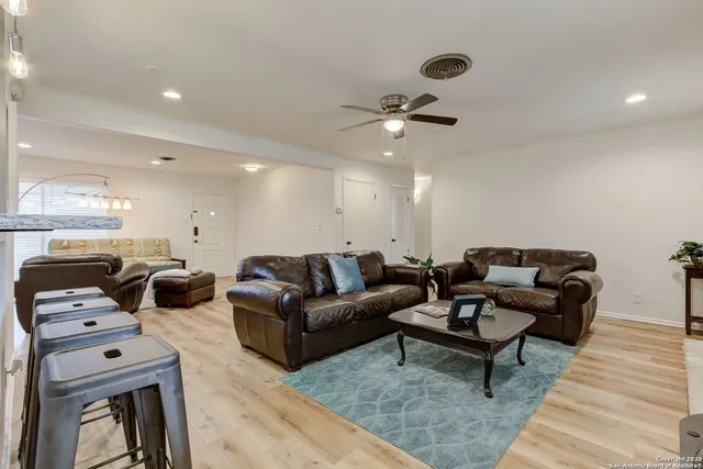 a living room with furniture ceiling fan and a rug