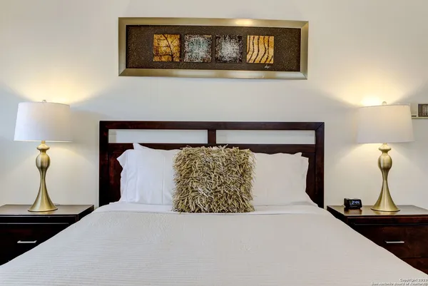 a bedroom with a bed and painting on the wall