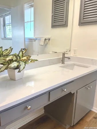 a bathroom with a sink a mirror and a window