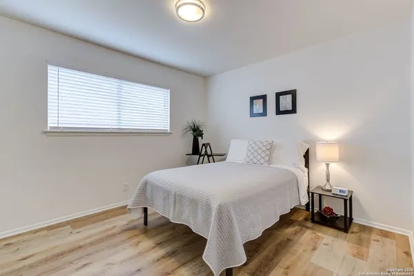 a large bed sitting in a bedroom next to a window and a lamp