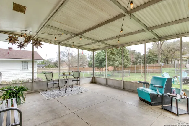 a view of a patio with table and chairs potted plants with floor to ceiling window