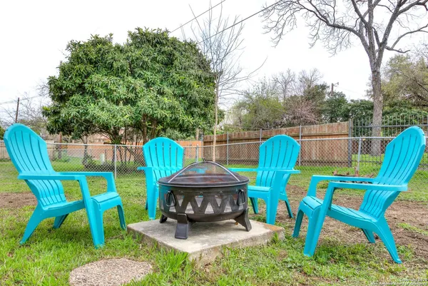 a view of a chairs and table in the back yard of the house