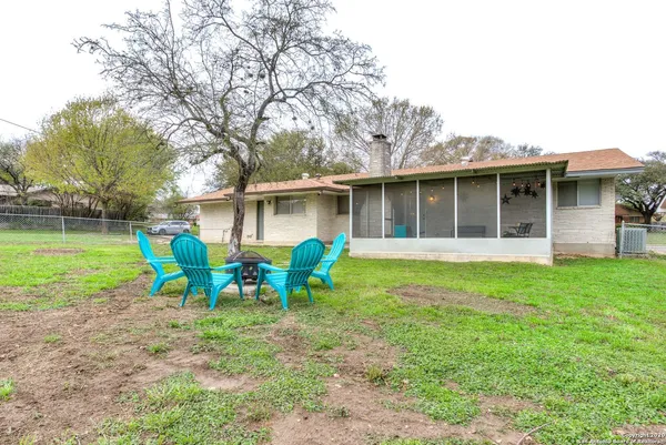a view of house with backyard and outdoor seating