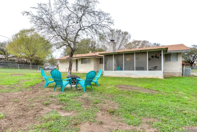 a view of house with backyard and outdoor seating
