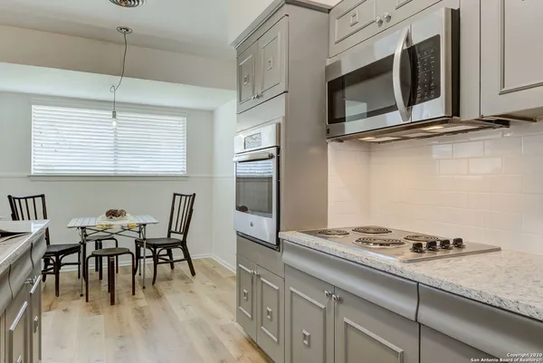 a kitchen with a stove a microwave and a dining table