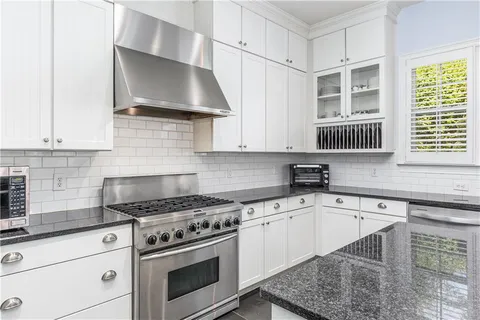 a kitchen with granite countertop a stove a sink and a microwave