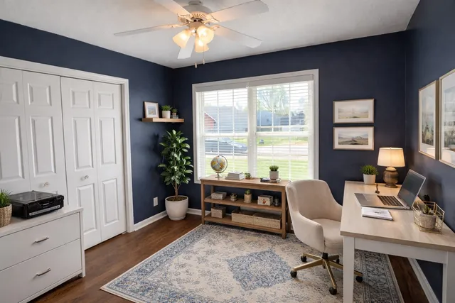 a view of a workspace with furniture and a window