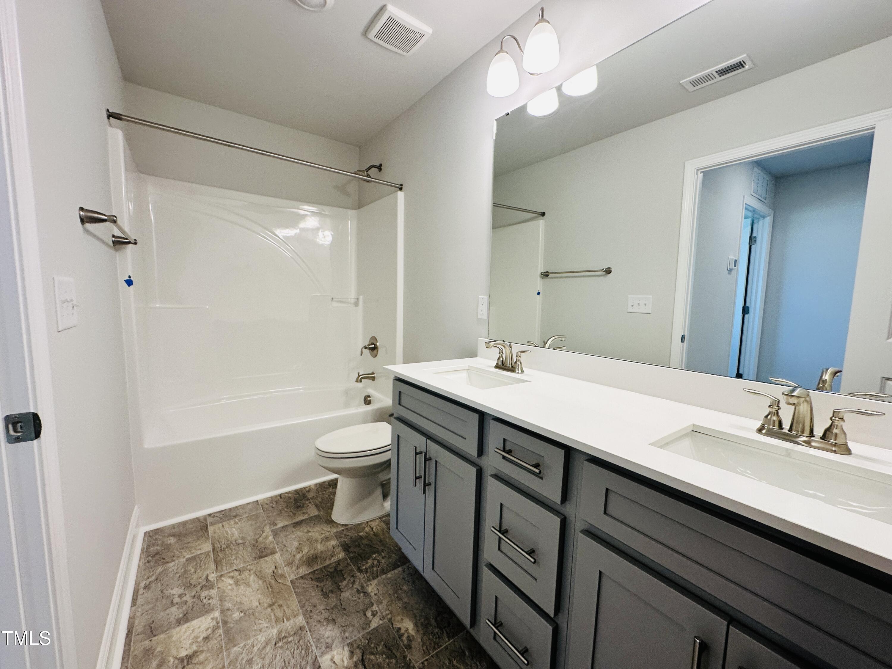 3982 Fletcher Road Bailey, NC 27807 - Photo 12 of 28 a bathroom with a double vanity sink a toilet and shower