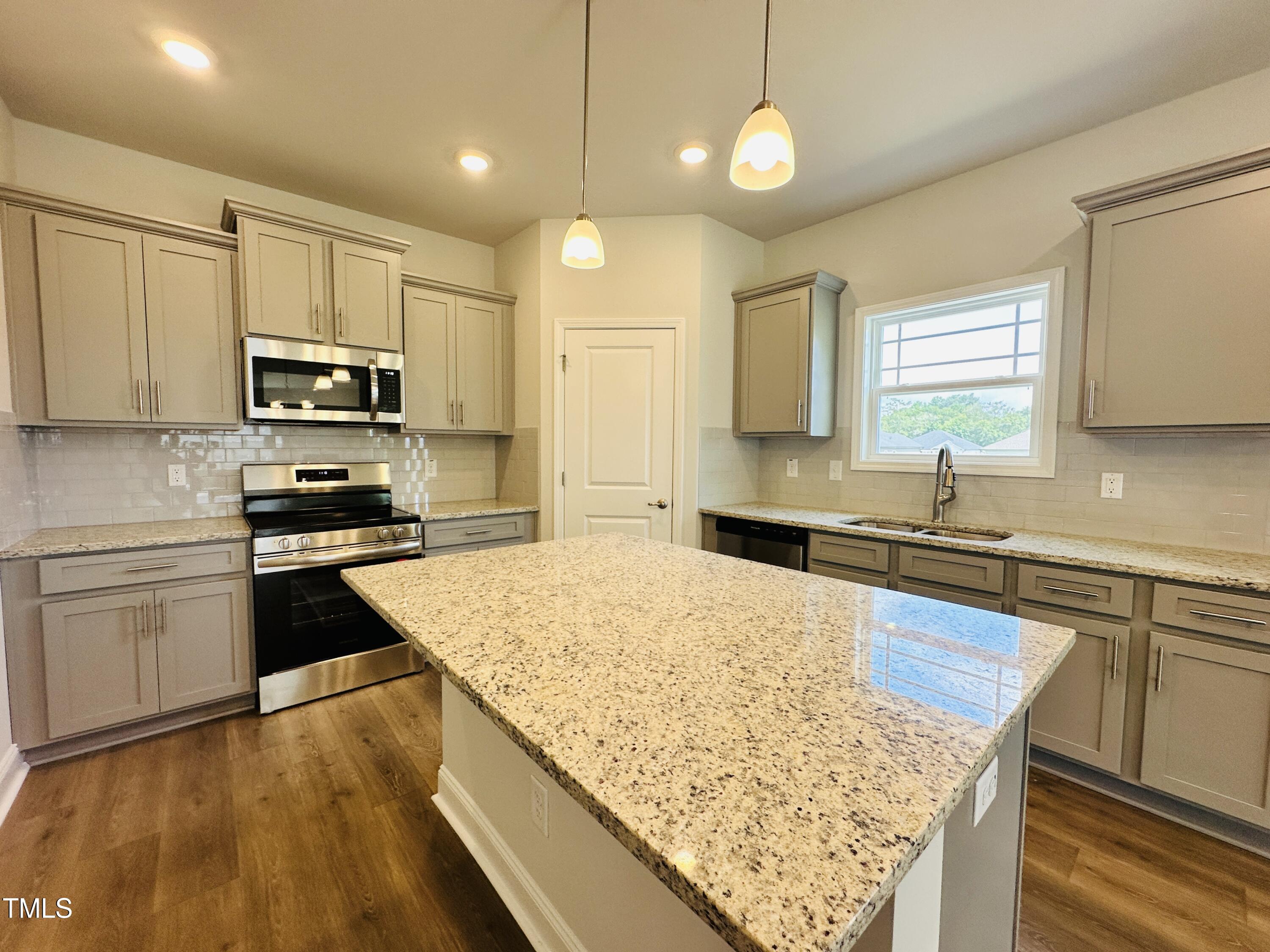 3982 Fletcher Road Bailey, NC 27807 - Photo 7 of 28 a kitchen with kitchen island granite countertop wooden cabinets granite counter tops and a stove