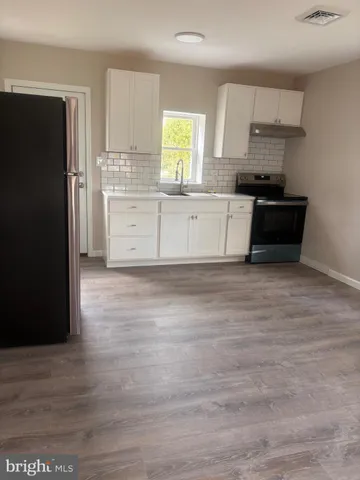 a kitchen with stainless steel appliances granite countertop a refrigerator and a stove