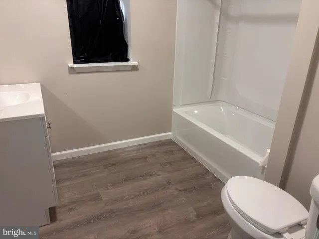 a white toilet sitting next to a bathtub