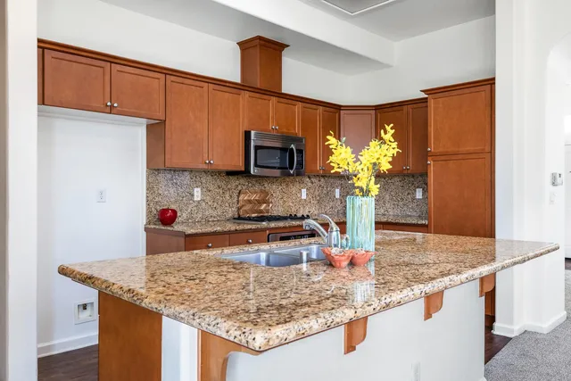 a kitchen with kitchen island granite countertop a sink a counter and cabinets