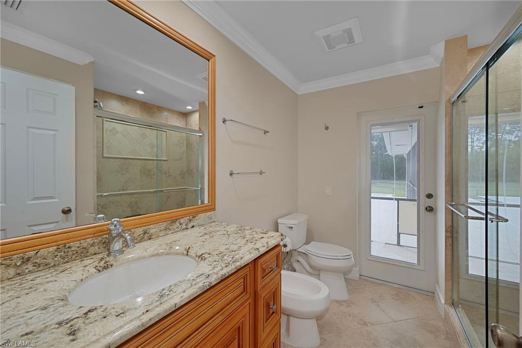 6440 Sable Ridge Lane Naples, FL 34109 - Photo 12 of 20 Full bathroom featuring a bidet, a shower stall, crown molding, vanity, and light tile patterned floors