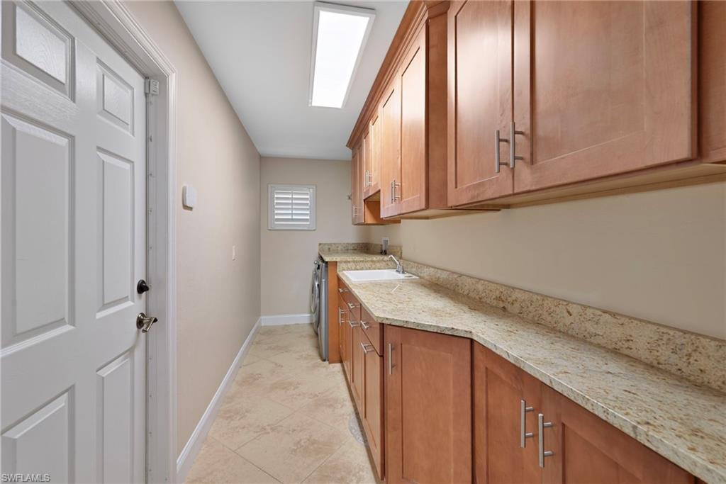 6440 Sable Ridge Lane Naples, FL 34109 - Photo 15 of 20 Laundry room featuring cabinet space and a skylight
