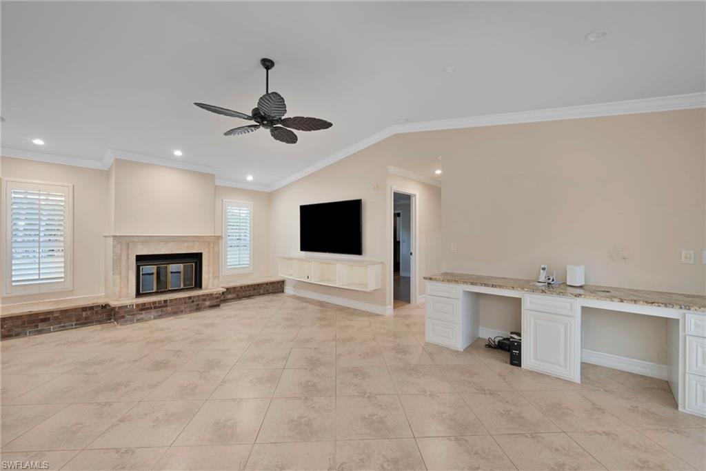 6440 Sable Ridge Lane Naples, FL 34109 - Photo 4 of 20 Unfurnished living room featuring ornamental molding, vaulted ceiling, recessed lighting, ceiling fan, and a desk