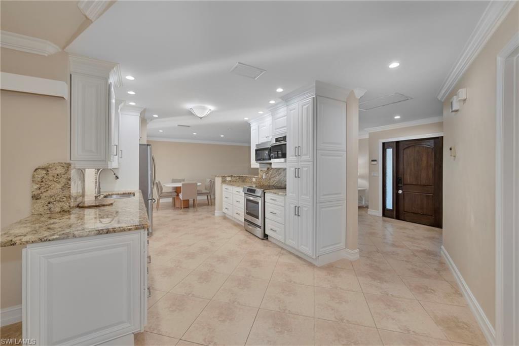 6440 Sable Ridge Lane Naples, FL 34109 - Photo 7 of 20 Kitchen with light stone counters, crown molding, appliances with stainless steel finishes, white cabinetry, and recessed lighting