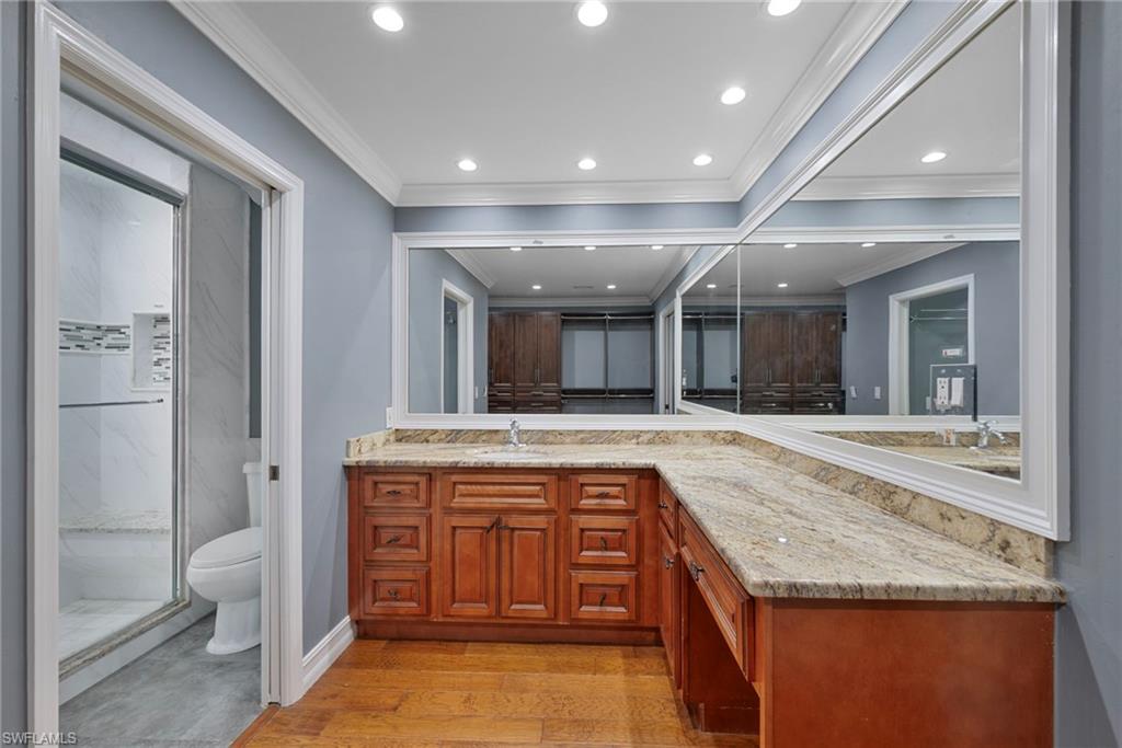 6440 Sable Ridge Lane Naples, FL 34109 - Photo 9 of 20 Bathroom with vanity, recessed lighting, light wood-style flooring, crown molding, and a marble finish shower
