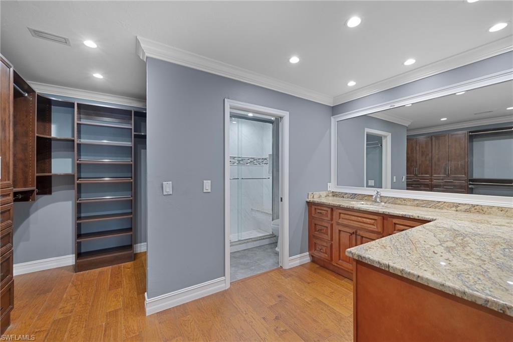 6440 Sable Ridge Lane Naples, FL 34109 - Photo 10 of 20 Bathroom with a walk in closet, vanity, crown molding, light wood finished floors, and recessed lighting