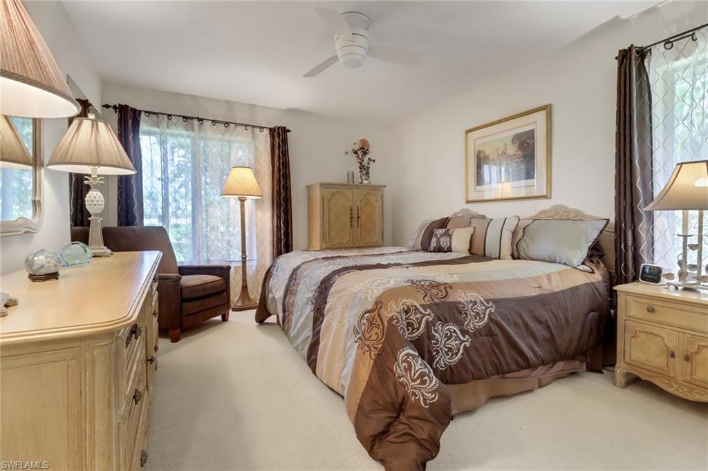 12902 Valewood Drive Naples, FL 34119 - Photo 16 of 22 a bedroom with a bed a mirror and a window