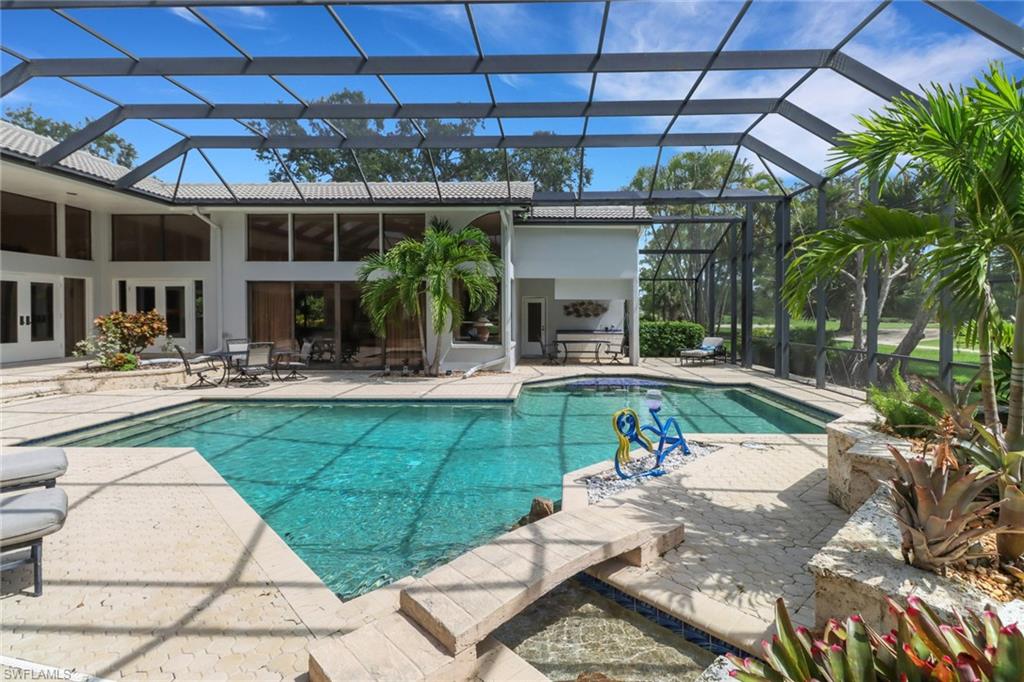 12902 Valewood Drive Naples, FL 34119 - Photo 19 of 22 a view of a swimming pool with a patio