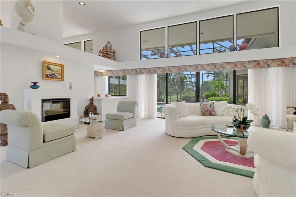 12902 Valewood Drive Naples, FL 34119 - Photo 3 of 22 a living room with furniture large window and a fireplace