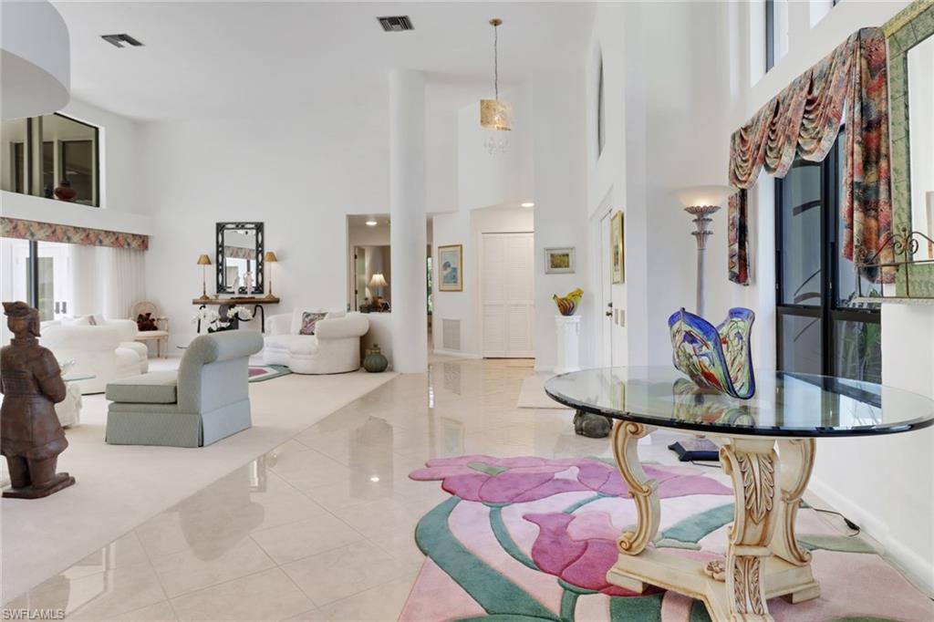12902 Valewood Drive Naples, FL 34119 - Photo 4 of 22 a living room with furniture a flat screen tv and kitchen view