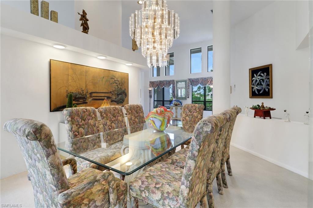 12902 Valewood Drive Naples, FL 34119 - Photo 5 of 22 a living room with furniture a chandelier and a flat screen tv