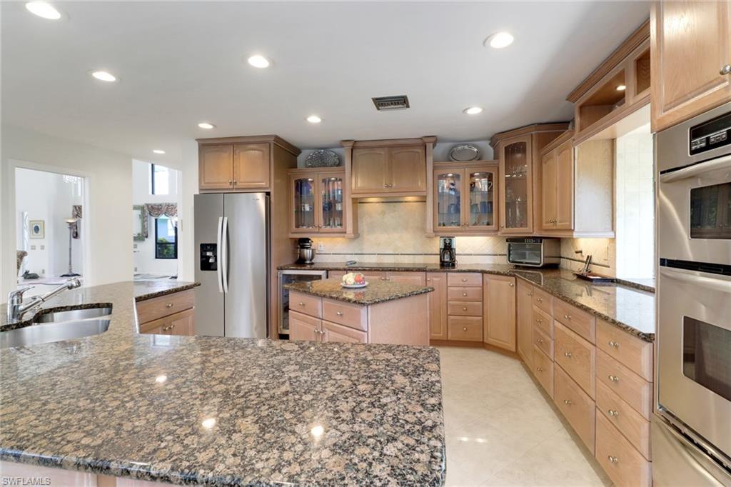 12902 Valewood Drive Naples, FL 34119 - Photo 8 of 22 a large kitchen with stainless steel appliances kitchen island granite countertop a large counter top stainless steel appliances and cabinets
