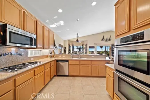 a kitchen with stainless steel appliances granite countertop a refrigerator a stove a sink and dishwasher