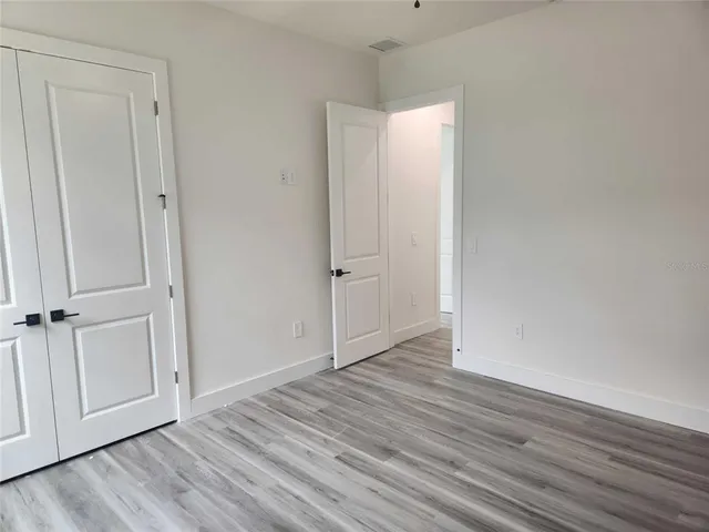 a view of an empty room with wooden floor