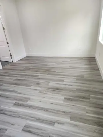 a view of an empty room and wooden floor